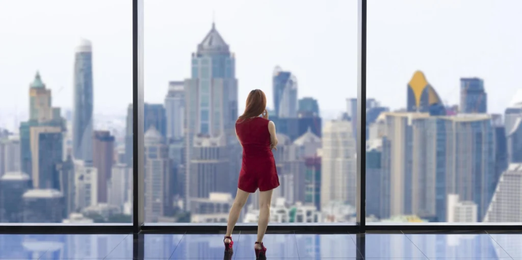 luxury young asian ceo woman entrepreneur looking at the downtown skyline at the window with skyscraper and cityscape for vision and real estate development free photo scaled 1