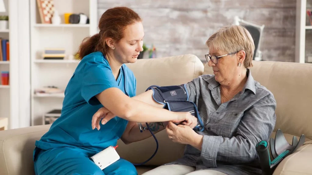 female nurse using digital blood pressure device senior woman nursing home 482257 22519